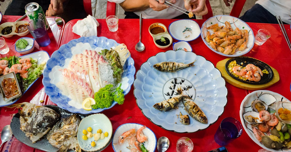 Colorful display of various seafood dishes enjoyed by people at a lively meal.