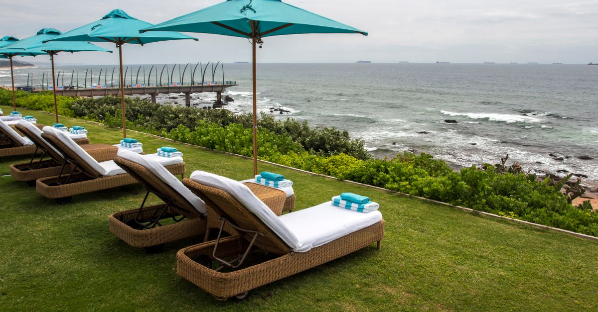 Luxurious loungers and umbrellas overlooking the ocean, perfect for a relaxing getaway.